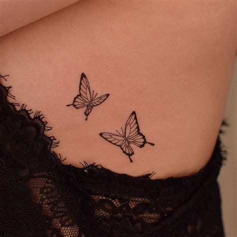 Fine line butterflies tattooed on the side boob.