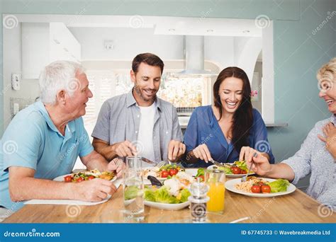 Family Laughing While Sitting At Dining Table Stock Photo - Image: 67745733