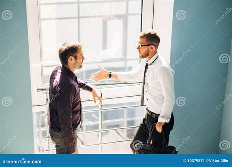 Two Men Talking in the Lobby of the Office Stock Image - Image of ...