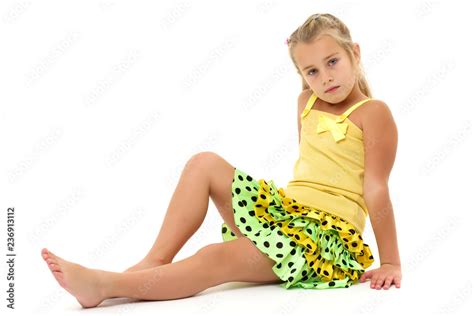 Little girl is sitting on the floor. Stock Photo | Adobe Stock