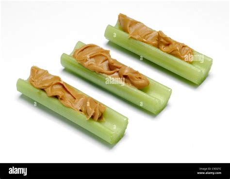 Three celery sticks with peanut butter Stock Photo - Alamy