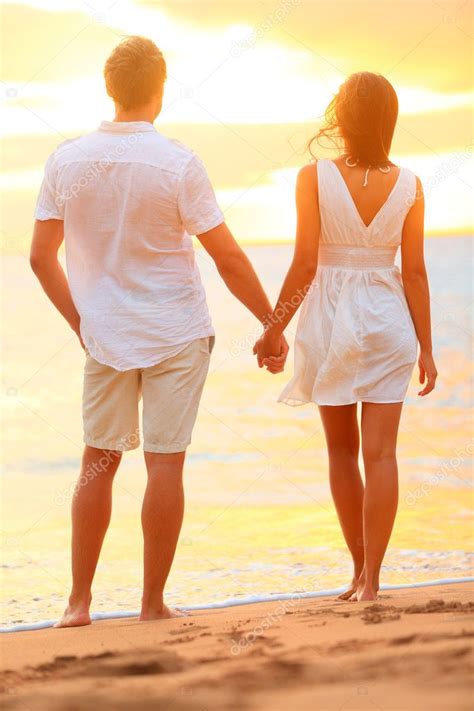 Young couple holding hands at beach sunset — Stock Photo #25234833