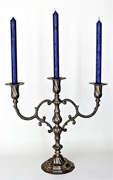 Royalty-Free photo: Gray metal 3-candle holder with three blue unlit candles | PickPik