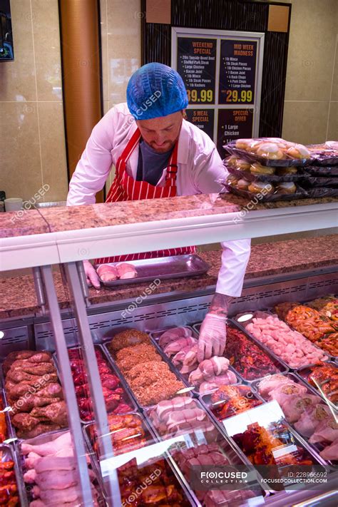 Butcher checking the meat display in butchers shop — fresh, Variety - Stock Photo | #228966692