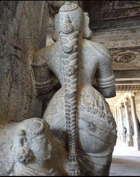 A stone sculpture of a woman with a long embellished braid at the Bhu Varaha Swamy temple in ...