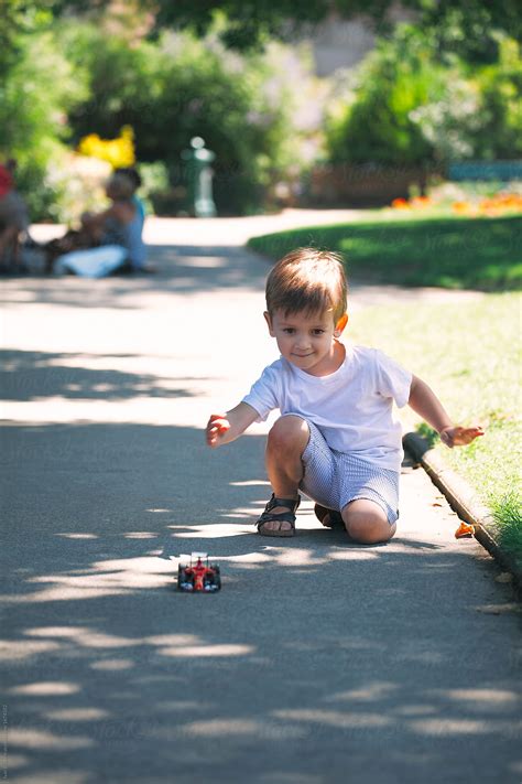 "Cute Little Boy Playing With A Car Toy In A Park In Paris In Summer ...