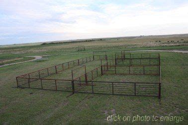 an aerial view of a field with cattle pens in the foreground and dirt ...