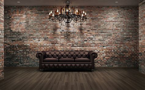 a couch sitting in front of a brick wall with chandelier hanging from it