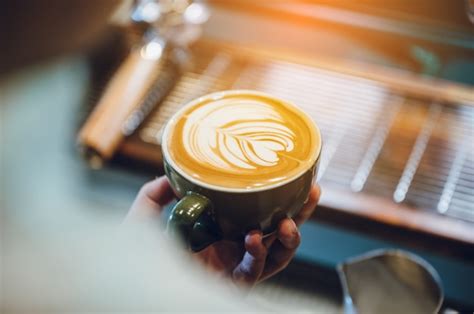 Premium Photo | Barista making latte art, shot focus in cup of milk and coffee,