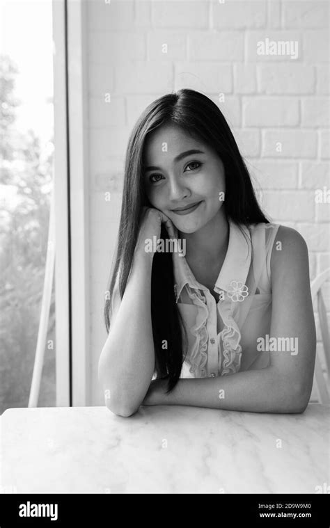 Young beautiful Asian woman relaxing at the coffee shop Stock Photo - Alamy