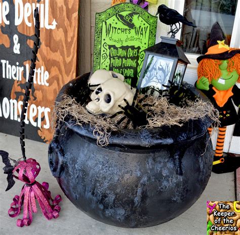 an outdoor halloween decoration with fake skulls in a black pot and ...