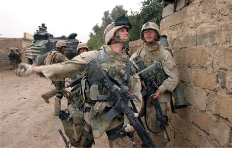 [Iraq] A U.S Marine tosses a hand grenade over a wall and into a courtyard during the Second ...