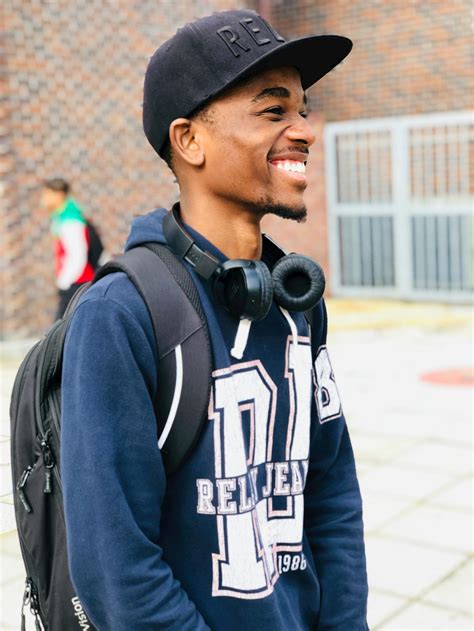 Man Wearing Black Cap, Blue Hoodie and Backpack · Free Stock Photo