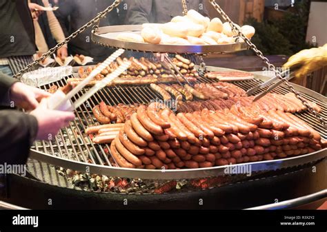 Grilling sausages on barbecue grill at a food stall of Christmas market ...