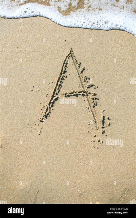 Letter drawn on the sand beach Stock Photo - Alamy