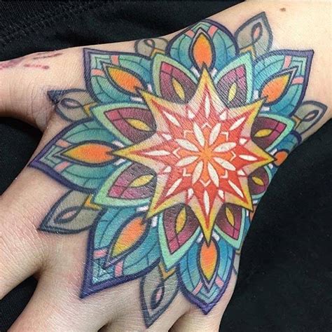 Colored mandala tattoo on the left hand.