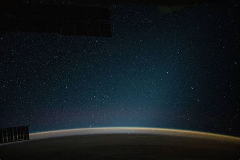 An atmospheric glow blankets Earth beneath a starry night sky - NASA