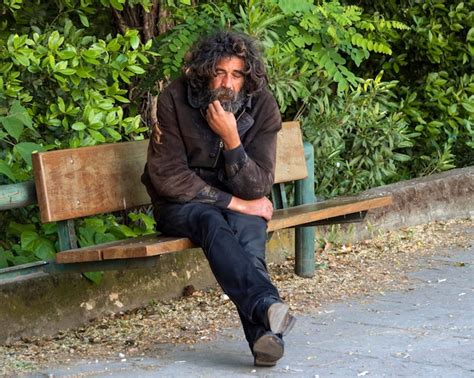 Premium Photo | Homeless man on the street sitting on a bench with a ...