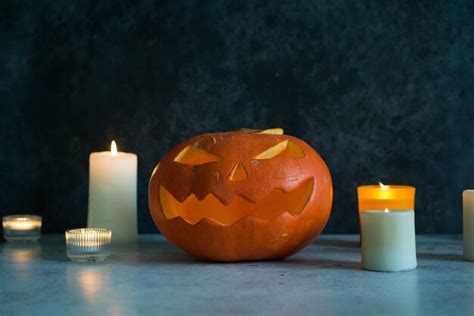 Premium Photo | A carving pumpkin with candles on gray background