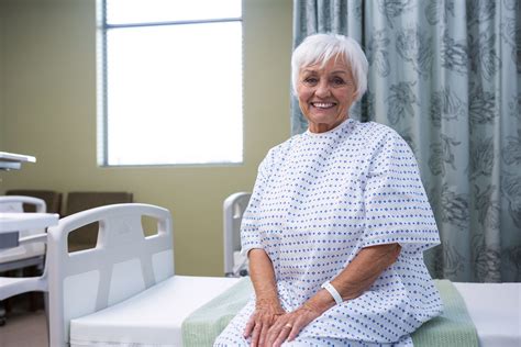 Smiling senior patient sitting on bed in hospital Photo from Pikwizard