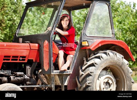 Beautiful woman driving tractor Stock Photo - Alamy