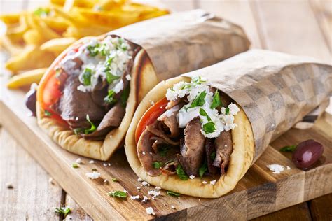 greek lamb meat gyros with tzatziki sauce, feta cheese and french fries ...