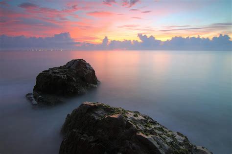 Two Rock Formation on Body of Water during Golden Hour · Free Stock Photo