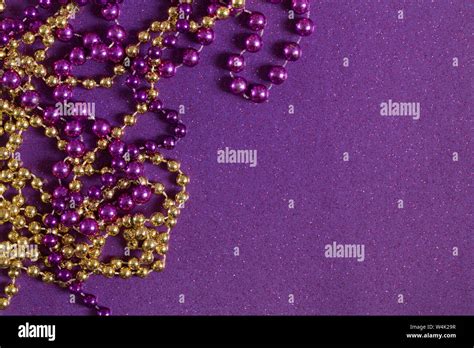 Mardi Gras Beads on a Purple Glitter Background Stock Photo - Alamy