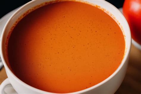 Premium AI Image | A cup of tomato soup with a small amount of steam coming out of it.