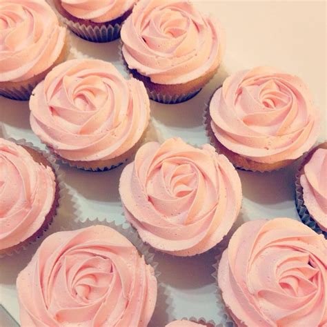 cupcakes with pink frosting arranged on a plate