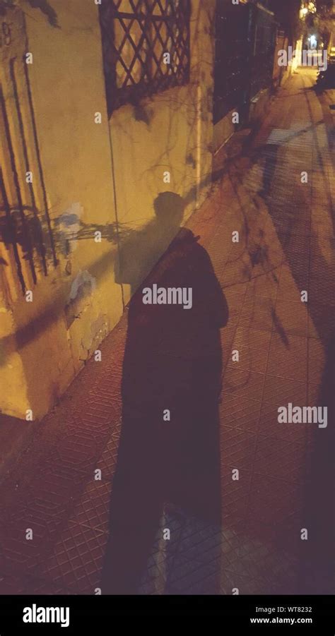 Shadow Of Man On Sidewalk At Night Stock Photo - Alamy