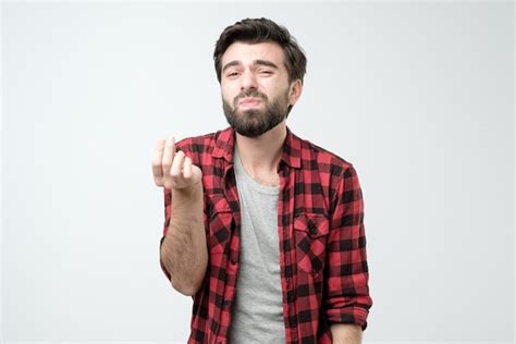 Premium Photo | Young man with a beard showing italian gesture that ...