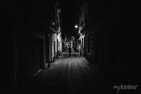 Woman walking alone in the street late at night.narrow dark alley ...