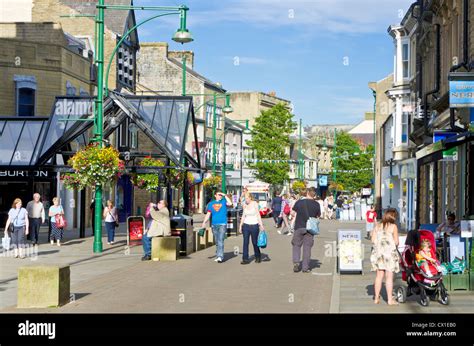 People walking on the main shopping street Buxton Spa Town centre ...