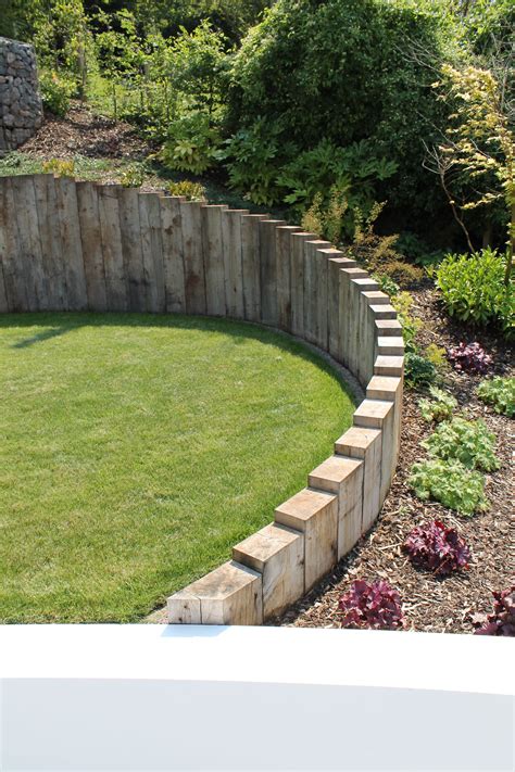 Oak sleepers are used through out the project, set vertically to follow organic curves, retain ...