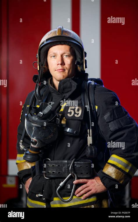 Photo of serious fireman wearing helmet with gas mask on background of fire engine Stock Photo ...