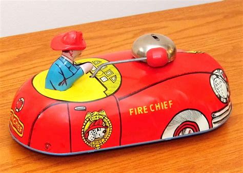 a red toy fire truck with a man in the front sitting on top of it