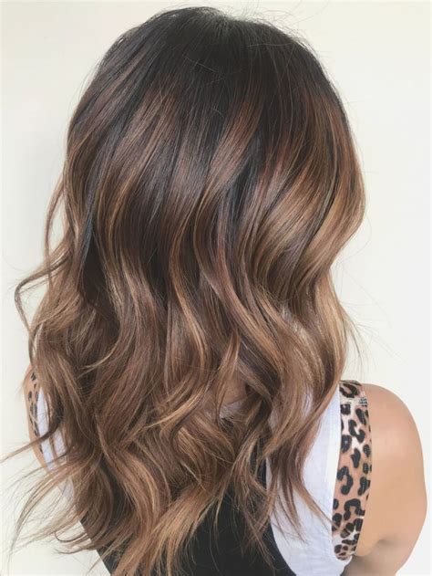 Faits saillants de balayage au caramel sur les cheveux de balayage brune. Les reflets ...