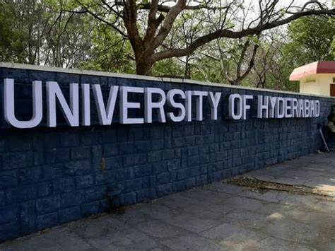 people are sitting on the bench in front of a sign that says university ...