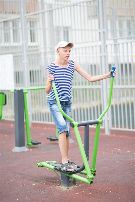 Boy Teenager Engaged In Children`s Exercise Equipment Stock Photo ...