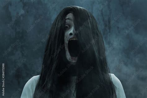 Scary ghost woman screaming on dark background Stock Photo | Adobe Stock