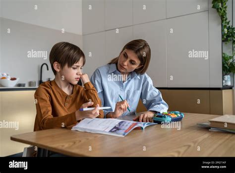 Upset stressed child boy feeling frustrated while doing homework with mom at home Stock Photo ...