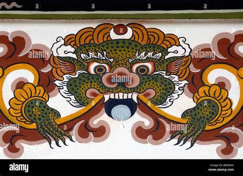 Representation of a dragon painted in traditional Bhutanese style on the concrete wall of a new ...