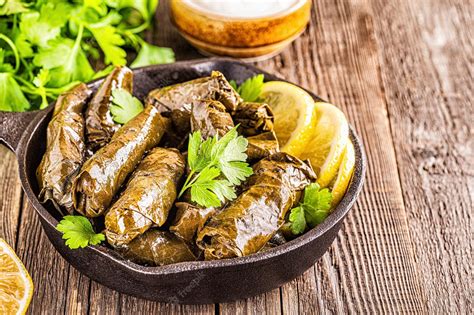 Premium Photo | Dolma, stuffed grape leaves with rice and meat on dark background, selective focus.