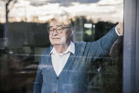 Portrait of serious man at the window looking out stock photo