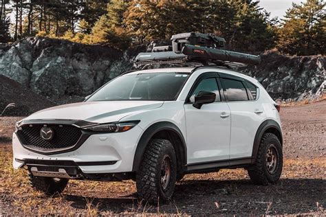 a white mazda cx - 5 parked in the woods