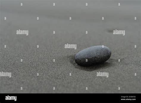 Smooth Rock on Sandy Beach with copy space to left Stock Photo - Alamy