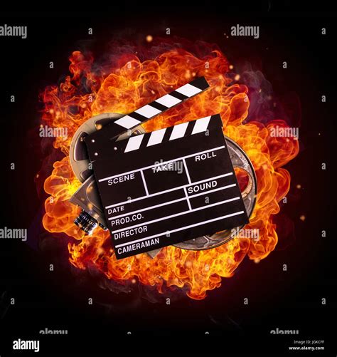 Film clapper, reel and camera in fire, isolated on black background. Concept of filmmaking Stock ...