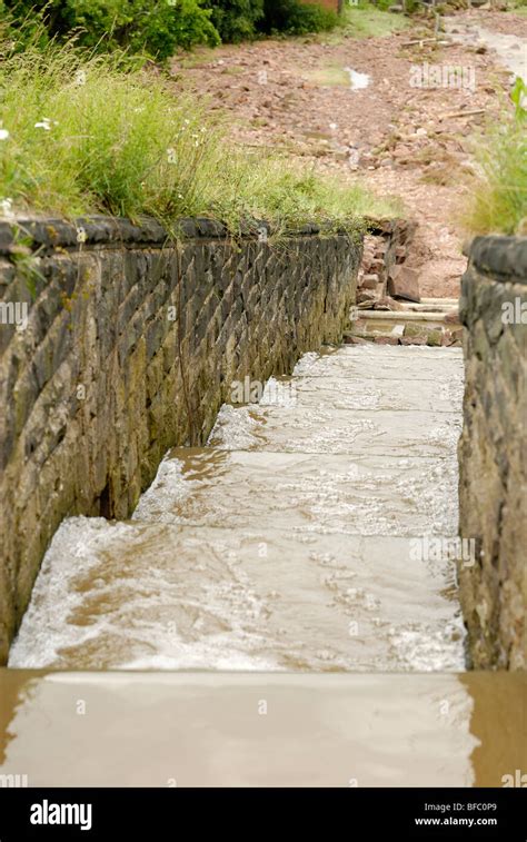 Dam spillway overflow with water running down Stock Photo - Alamy