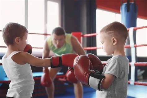 Little boy training with coach and punchbag in boxing gym — Stock Photo ...